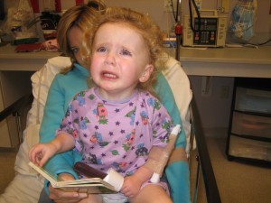 Sitting in Erika's lap, with a book and a popsicle (not happy)