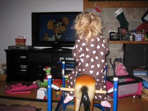 Riding the horse and watching TV!